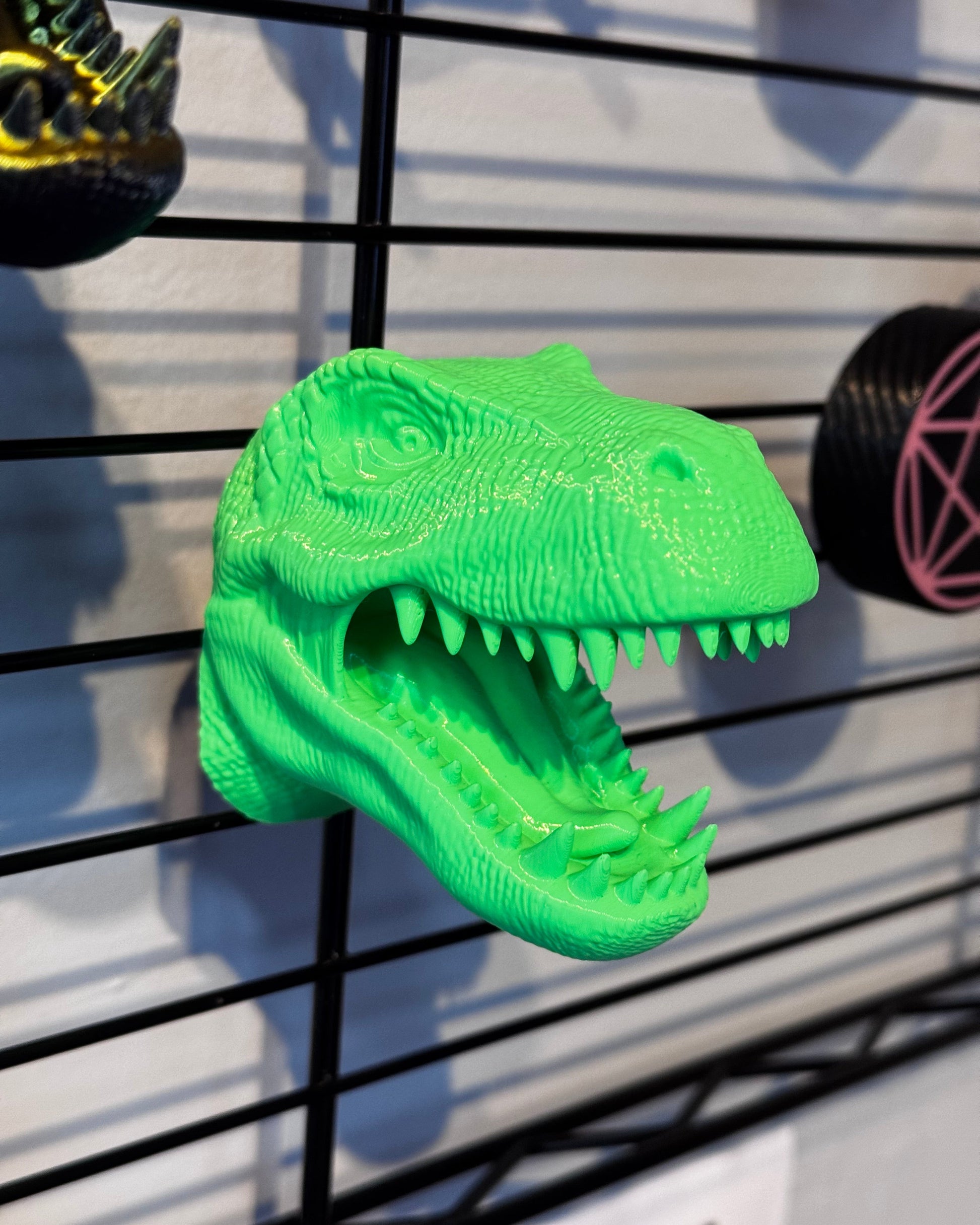 Green dinosaur magnet on a metal surface