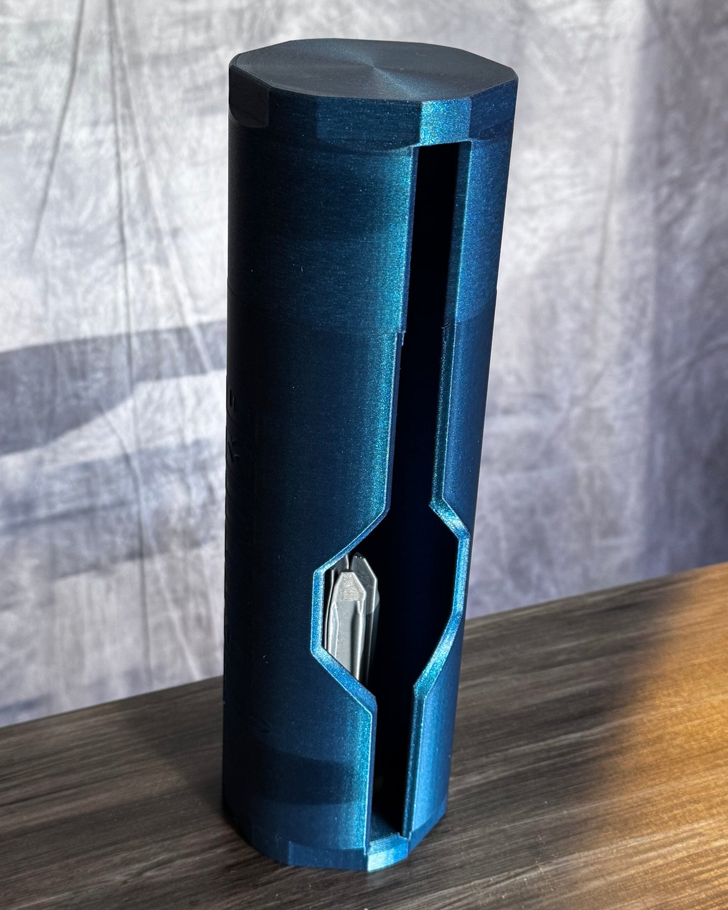 Blue cylindrical object on a wood textured surface